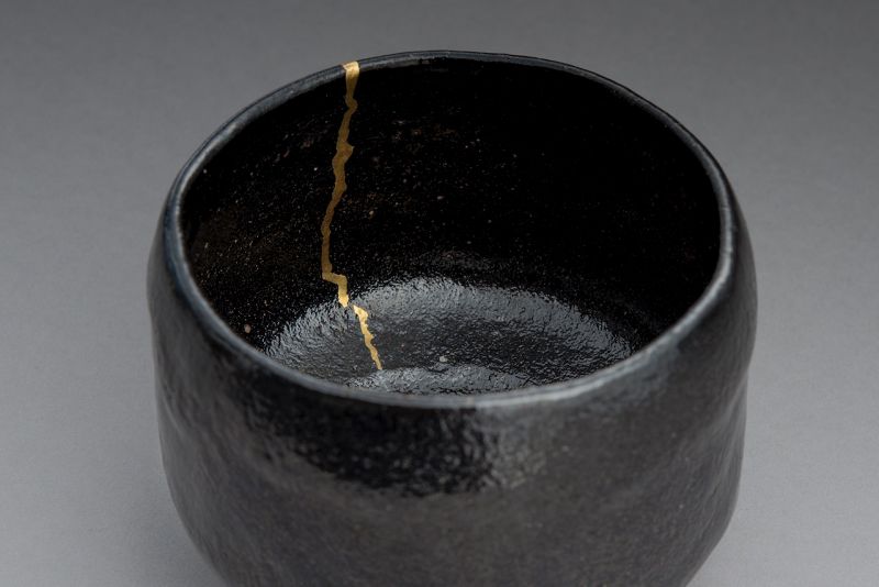 An Antique Black Raku Tea Bowl with Gold Repair