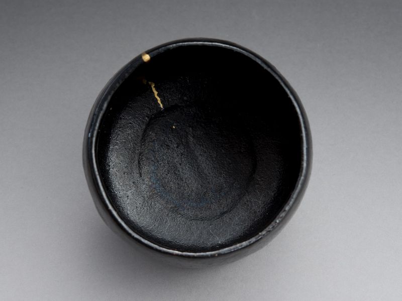 An Antique Black Raku Tea Bowl with Gold Repair