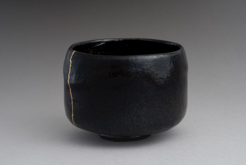 An Antique Black Raku Tea Bowl with Gold Repair
