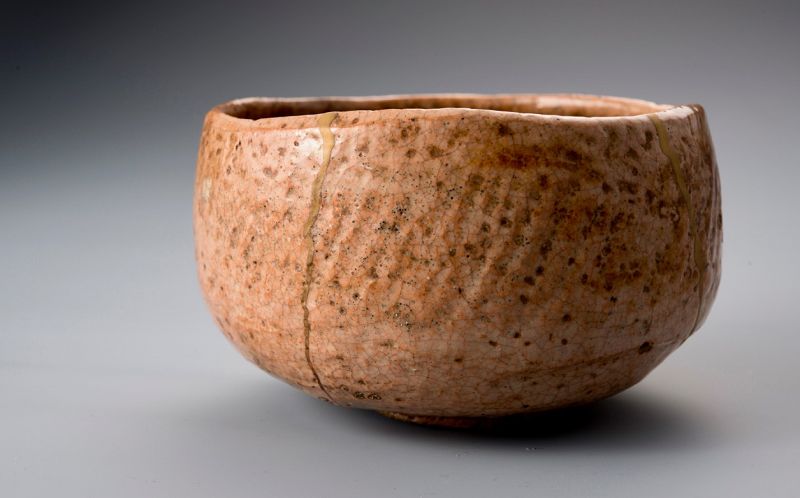 A Rare Tamamizu Red Raku Tea Bowl with Gold Repairs